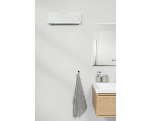 Modernt badrum med luftkonditionering, spegel, tvättställsskåp och handduk