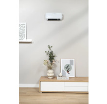 Vardagsrum med väggmonterad fläkt över en byrå dekorerad med en vas