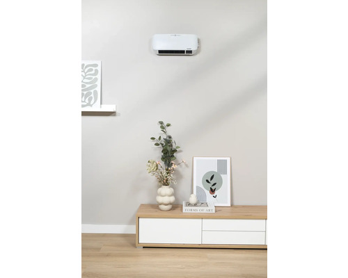 Vardagsrum med väggmonterad fläkt över en byrå dekorerad med en vas