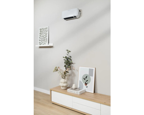 Väggmonterad fläkt över skänk med dekoration och tavlor.