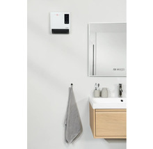 Modernt badrum med värmefläkt, spegel, handfat och handduk