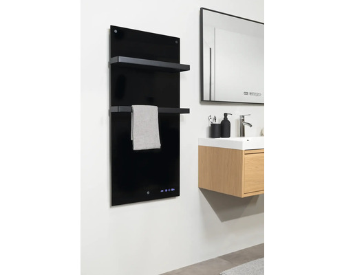 Badrum med svart handdukstork, handduk och tvättställ