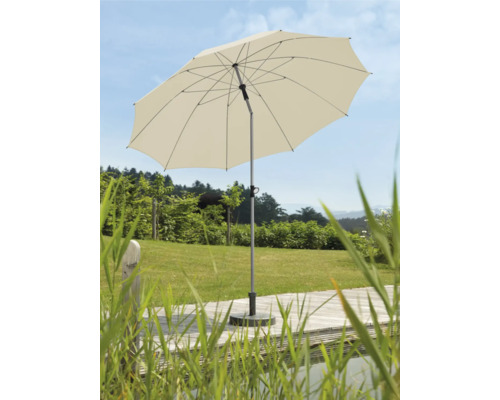 Öppet trädgårdsparasoll på en terrass med gräsmatta i bakgrunden