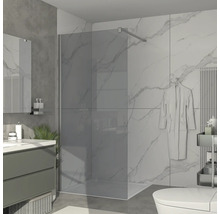 Modernt badrum med duschkabin, tvättställ och marmorplattor.