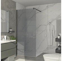 Badrum med duschvägg i glas, handfat och toalett.