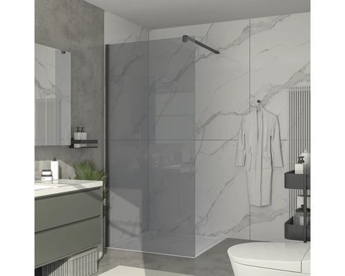 Badrum med duschvägg i glas, handfat och toalett.