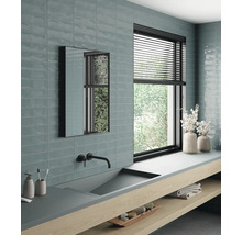 Ljust badrum med handfat, spegel, fönster och kakel