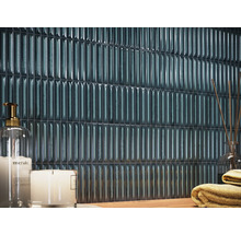 Väggkakel i ett badrum med ljus och handdukar