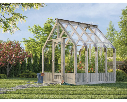 Växthus i trä med växter i trädgården