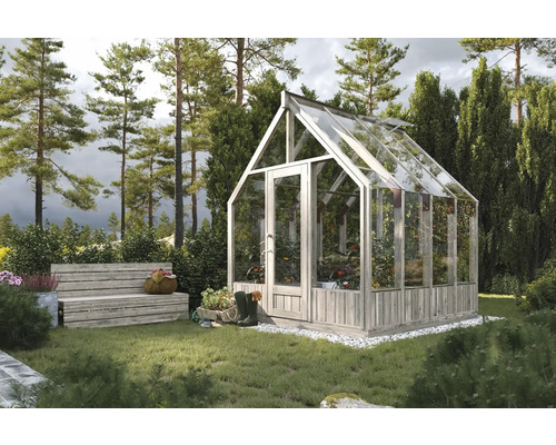 Växthus med växter och trädgårdssoffa i trädgården