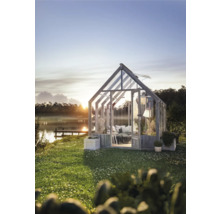 Växthus i trädgården med utsikt över sjön vid soluppgången.