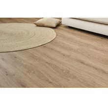 Ljust laminatgolv med träutseende med rund matta och kudde
