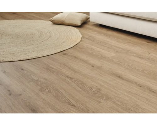 Ljust laminatgolv med träutseende med rund matta och kudde