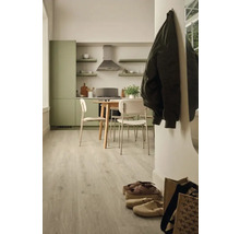 Ljust köksutrymme med matbord och stolar samt golv med träutseende