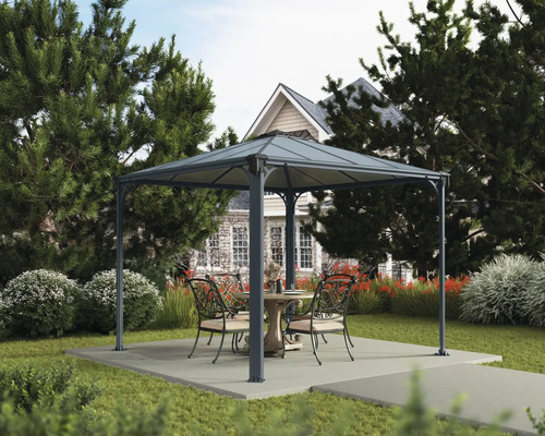 Trädgårdsscen med lusthus, bord och stolar på en terrass