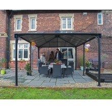 Trädgårdspaviljong med familj och matbord utomhus framför tegelbyggnad