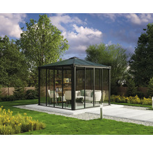 Trädgårdspaviljong med glasväggar, sittmöbler och en bokhylla på en terrass i trädgården.