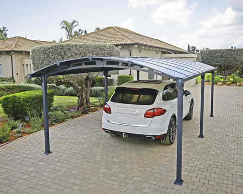 Bil under en carport på en asfalterad uppfart