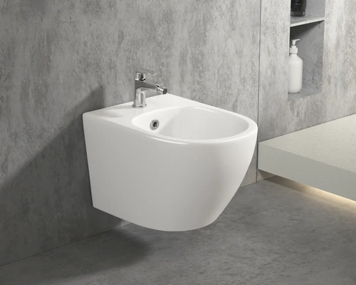 Vägghängd bidé med armatur i ett badrum.