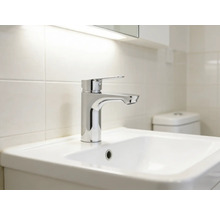 Tvättställ med blandare i ett ljust badrum.