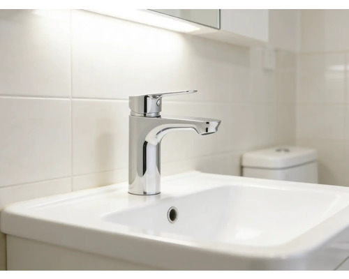 Tvättställ med blandare i ett ljust badrum.