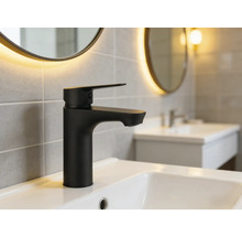 Svart tvättställsblandare på ett handfat i ett badrum.