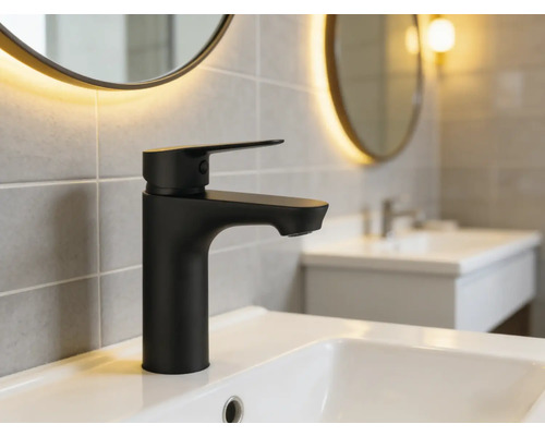 Svart tvättställsblandare på ett handfat i ett badrum.