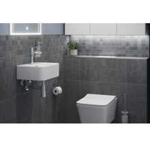 Badrum med handfat, toalett och grå kakel