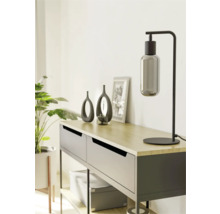 Dekorativ sidobord med bordslampa, vaser och krukväxt för en stilfull inredning