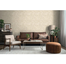 Vardagsrum med brun soffa, fåtölj, bord och mönstrad tapet