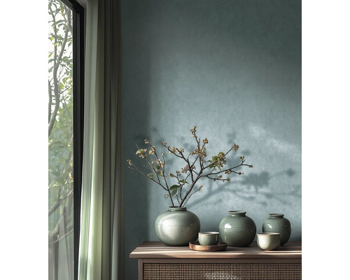 Dekorativ arrangemang med vaser och grenar på en skänk framför en vägg