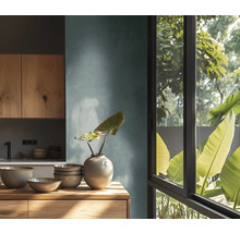 Ljust kök med träelement, porslin och växt i vas på en byrå