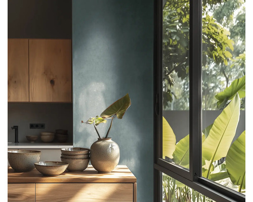 Ljust kök med träelement, porslin och växt i vas på en byrå