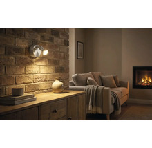 Vardagsrum med tegelvägg, byrå och vägglampa med två lampor