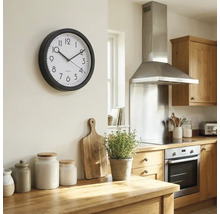 Köksscen med väggklocka, bänkskiva i trä och köksapparater