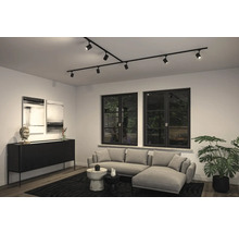 Vardagsrum med modernt takskenssystem med spotlights, soffa och byrå