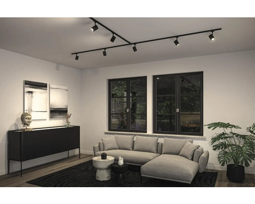 Vardagsrum med modernt takskenssystem med spotlights, soffa och byrå