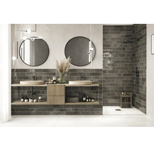 Modernt badrum med dubbla handfat, runda speglar och mörka plattor