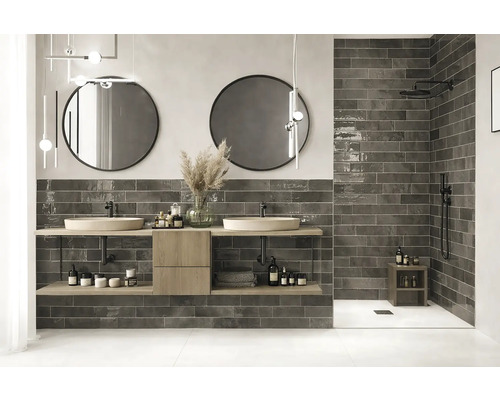 Modernt badrum med dubbla handfat, runda speglar och mörka plattor