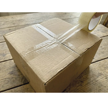 En kartong försluts med transparent tejp.