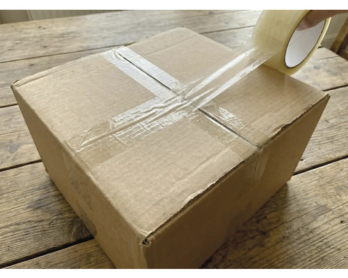 En kartong försluts med transparent tejp.