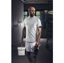 Hantverkare med t-shirt, shorts, hink och murslev på en byggarbetsplats