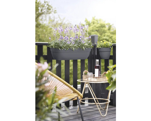 Balkongscen med planterad blomlåda och dekoration på ett litet bord.