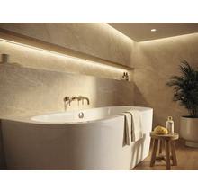 Ljust badrum med badkar, armatur och hylla med dekoration