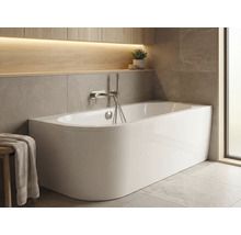 Fristående badkar i ljust badrum med förvaringsutrymme