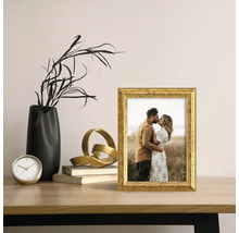 Dekorativ guldram på ett bord med andra dekorativa föremål