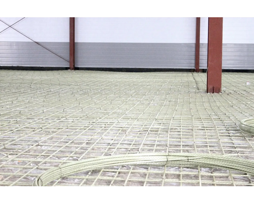 Scen av ett golv förberett med armeringsnät och stålstolpar för betongarbeten