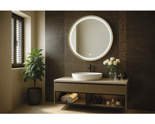 Modernt badrum med tvättställ, rund spegel med belysning och krukväxt