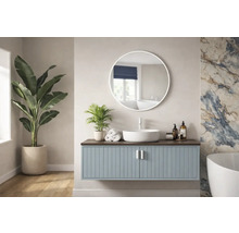 Ljust badrum med tvättställsskåp, rund spegel och krukväxter.