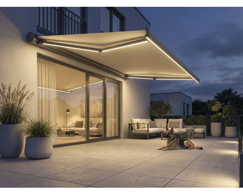 Belyst markis ovanför en uteplats med trädgårdsmöbler och en hund